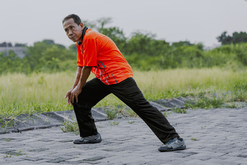 Stretching muscle, fitness and senior asian man in park for exercise, healthy body and wellness in retirement. Sports, nature and middle aged man ready for warm up, cardio workout and training outdoor