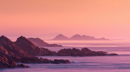 Fototapeta premium A beautiful scene unfolds with soft twilight hues painting the sky above a rocky coastline. Gentle waves lap at the shore while distant mountains create a serene backdrop.