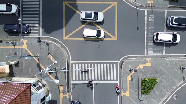 Aerial top view of busy urban traffic intersection with cars and motorcycles in Medan, Indonesia, February 15 2026