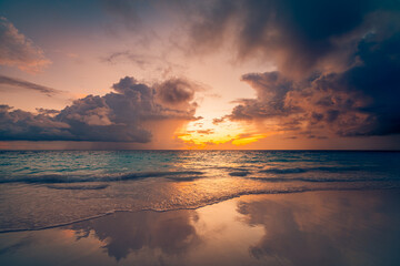 Fototapeta premium Dramatic sunset beach with gorgeous dream ocean view and turbulent clouds for inspiring travel background featuring tranquil nature landscape and majestic colorful horizon in the evening