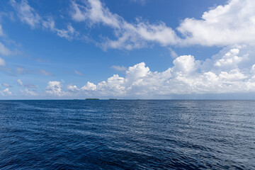 Fototapeta premium Relaxing blue ocean horizon under sunny blue sky for summer travel background with calm sea water and peaceful atmosphere for majestic nature landscape and minimalist coastal vacation art