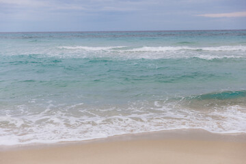 Costa Rei beach with calm turquoise Mediterranean Sea waves breaking on light sand, representing summer travel and vacation
