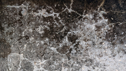 cracked asphalt surface texture with white frost pattern