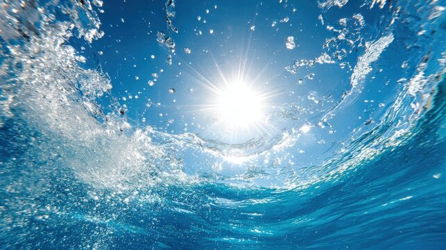 Brilliant sunlight illuminates splashing water surface viewed from beneath the ocean