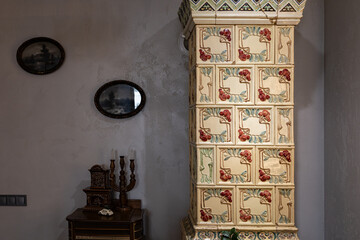 Naklejka premium Vintage Interior Featuring an Ornate Tiled Stove and Classical Decor