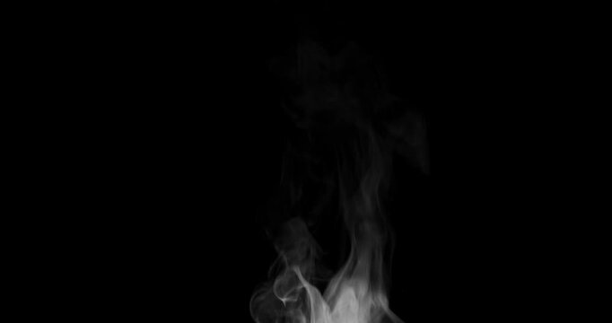White isolated steam rises in graceful curves on a black background in slow motion. This trickle of steam is perfect for overlay use with various blending modes, hot drinks or food concepts.
