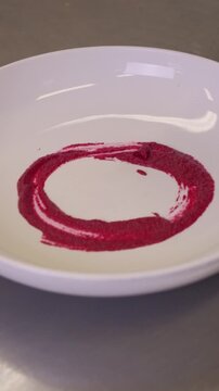 A beautifully crafted colorful ravioli is elegantly plated and garnished. The vibrant colors of the pasta contrast with the rich sauce. High quality FullHD footage
