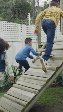Playing, children and running to backyard playground for climbing game, holiday fun and adventure. Friends, kids and energy on jungle gym at house for weekend break, physical development and bonding