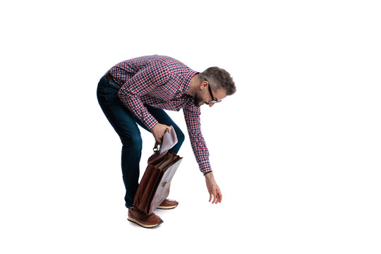 Side view of casual man reaching down towards ground