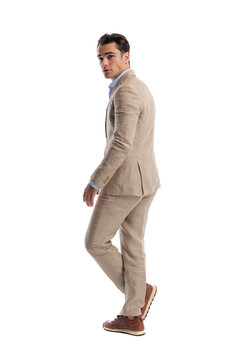 Back view of confident man walking and looking back