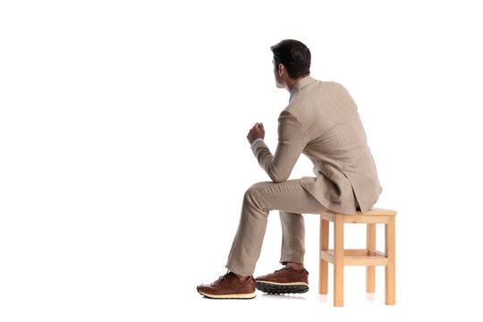 Back view of pensive man sitting on wooden chair