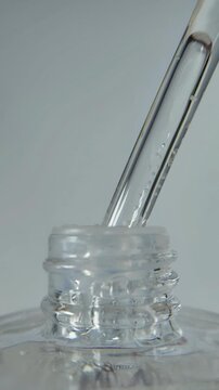 Close up view of beauty serum product. Natural serum. Clear liquid in pipette. Vertical view.