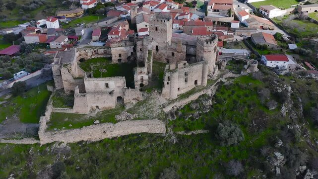 Aerial view of Belv&iacute;s de Monroy Castle, a medieval hilltop fortress ruins overlooking rural Caceres landscape, historic defensive architecture surrounded by countryside and open skies.