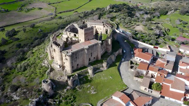 Aerial view of Belv&iacute;s de Monroy Castle, a medieval hilltop fortress ruins overlooking rural Caceres landscape, historic defensive architecture surrounded by countryside and open skies.