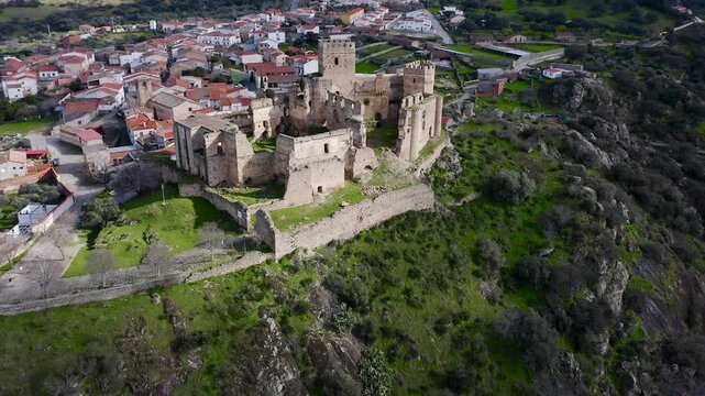 Aerial view of Belv&iacute;s de Monroy Castle, a medieval hilltop fortress ruins overlooking rural Caceres landscape, historic defensive architecture surrounded by countryside and open skies.