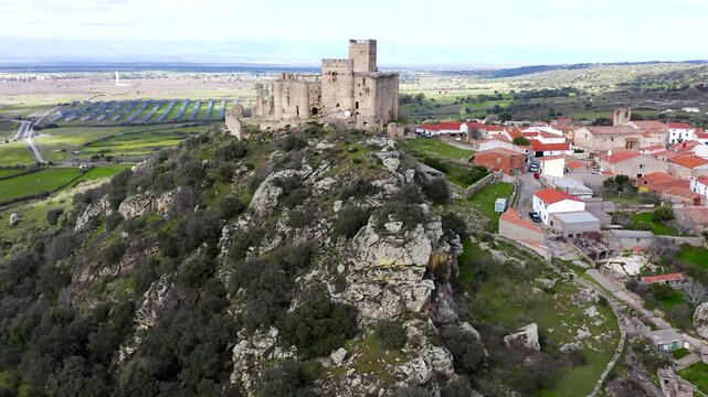 Aerial view of Belv&iacute;s de Monroy Castle, a medieval hilltop fortress ruins overlooking rural Caceres landscape, historic defensive architecture surrounded by countryside and open skies.