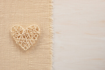 Decorative wicker rattan heart on a fabric background