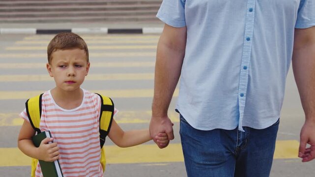Child with backpack crossing road, Safety first with family, Parent-child relationship, Watching out for cars, Dad and son walk together, Starting school safely, Young student on the move, Community