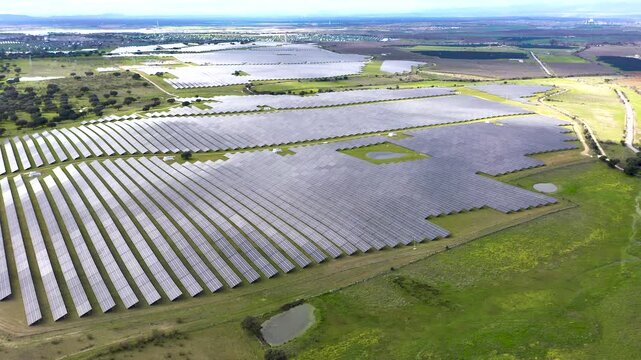 View of large solar power plant near Belv&iacute;s de Monroy Castle in C&aacute;ceres, Spain. Vast photovoltaic panels covering rural landscape, renewable energy infrastructure in Extremadura countryside.