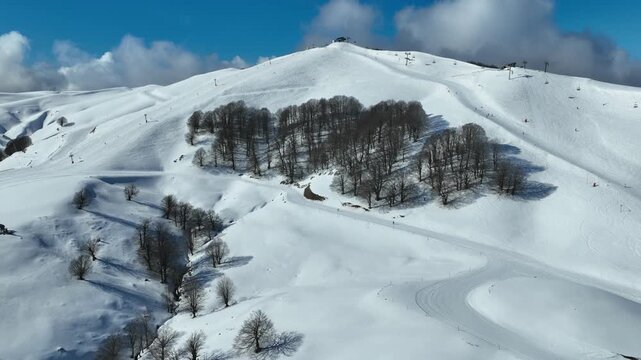 Aerial drone cinematic video of recently renovated snow center of Anilio Perched on the top of Pindus, with the comparative advantage of easy and direct access via the Egnatia Motorway, covered in sno