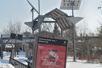 Obraz premium Bike Share Toronto docking station at Victoria Park Av and Dawes Road - behind is Dawes Crossing, a barn-like structure, honoring area's rural past