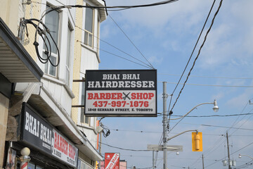 Obraz premium projecting sign outside Bhai Bhai Hairdresser located at 1248 Gerrard St E, Toronto
