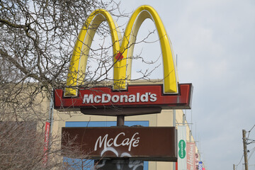 Naklejka premium iconic Golden Arches pylon sign at McDonald's Canada fast food restaurant chain located here at 1000 Gerrard St E, Toronto