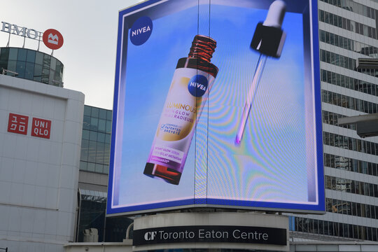 wide view of a digital billboard for Nivea over entrance to CF Toronto Eaton Centre, facing Sankofa Square