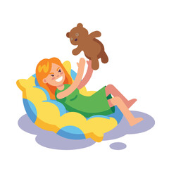 Happy girl playing with teddy bear on bean bag chair.