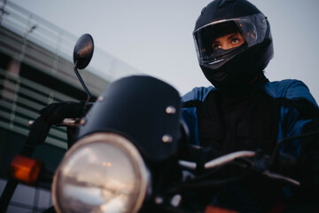 A female motorcyclist riding a motorcycle in the city in the evening