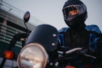 A female motorcyclist riding a motorcycle in the city in the evening