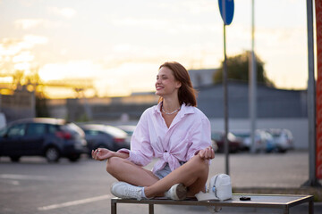 woman meditates on a bench on a city street, a concept of professional burnout and harmony.