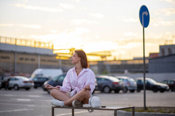 woman meditates on a bench on a city street, a concept of professional burnout and harmony.