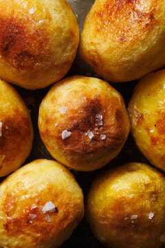 Delicious oven-baked potatoes with olive oil and salt flakes, close-up view