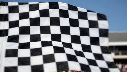 Obraz premium Close up of a checkered flag waving gently in the wind at a racetrack