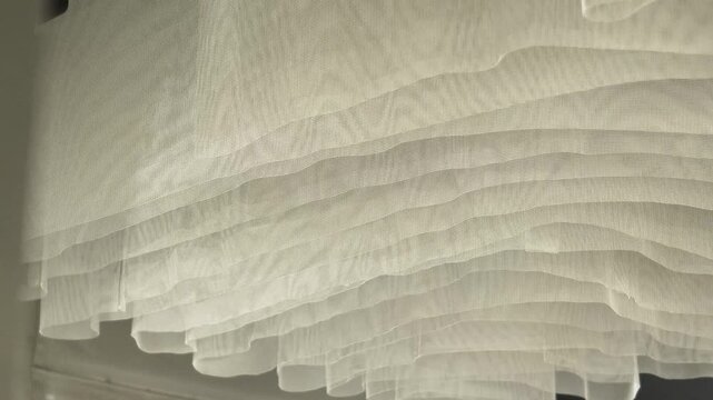 a suspended installation of white lightweight fabric on the ceiling is developing in the wind. ceiling decor, interior design, ceiling design