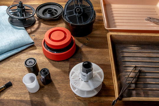 Equipment for analog photography, developing tray, tongs in the tray, film roll.
