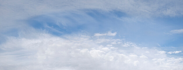 Fototapeta premium heaven skies blue and clear, with thin, puffy, transparent clouds. and moon is visible through them. sun shines brightly, making sky even brighter. scene is peaceful and serene