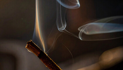 Close-up of cigarette smoke rising.
