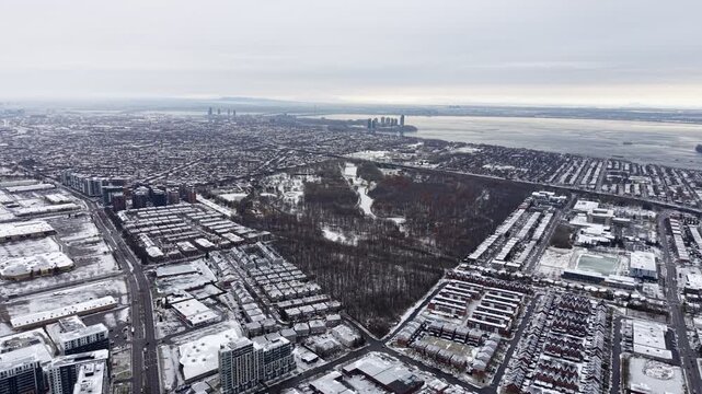 Aerial winter view of Montreal suburbs, snowy angrignon park and river near Lachine and Verdun under cloudy sky. g.