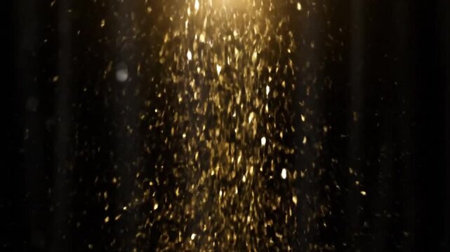 A dazzling stream of golden, shimmering particles gracefully falls downwards against a dark, subtle background, illuminated by a bright light source from above.