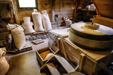 Inside the old wooden flour grinding mill. Interior of retro wooden watermill with old equipment for grinding or milling grain into flour © Ivan