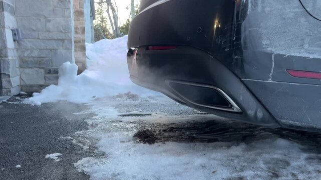 Modern Car Exhaust Pipe Emitting Smoke in Winter Snow Environment