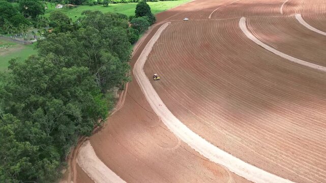 Aerial drone video of tractor working in agricultural field, modern farming