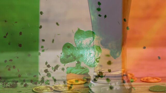 Shamrock cutout above cupcake, confetti starting to fall and settling to celebrate Irish motif