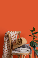 Warm plaids on chair near orange wall