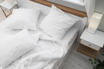 Big comfortable bed with white bedding in hotel room