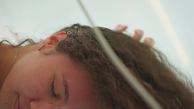 Female of mixed race cleansing damp curls. Bicultural woman refreshing wet hair under shower stream. Mixed ethnicity woman rinsing moist ringlets in hotel shower with steam and droplets