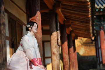 전통 한옥 기둥 아래, 한복 여인의 따스한 오후