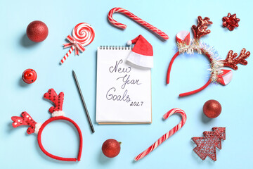 Notebook with text NEW YEAR GOALS 2026 and Christmas decor on blue background